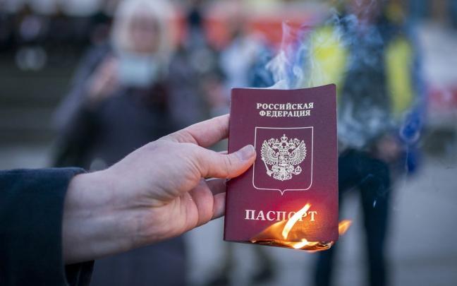 Un pasaporte ruso es quemado. Un pasaporte ruso es quemado.