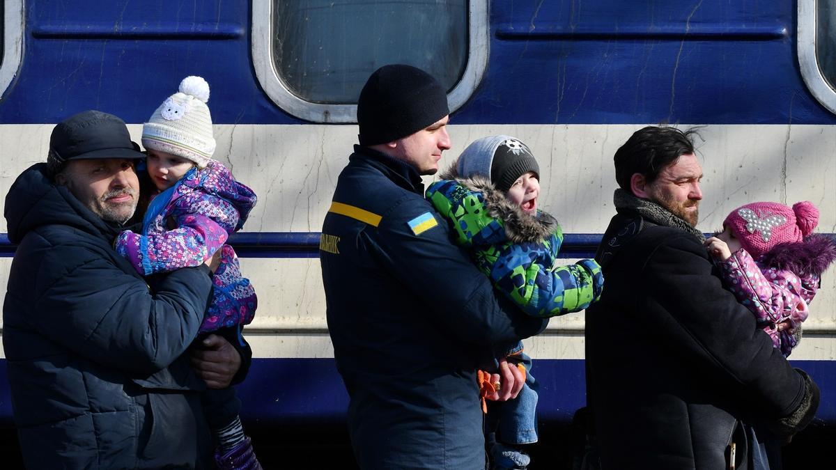 Niños ucranianos con sus padres antes de subirse a un tren.