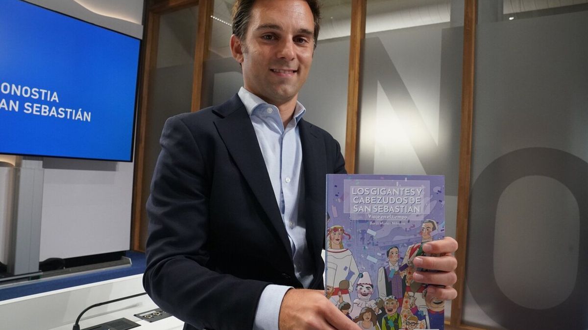 Borja Muñoz muestra su libro sobre la historia de los gigantes y cabezudos de Donostia.