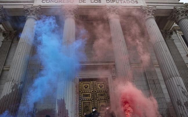 Humo lanzado por los manifestantes en una acci&oacute;n de desobediencia para pedir m&aacute;s ambici&oacute;n en la lucha contra el calentamiento.