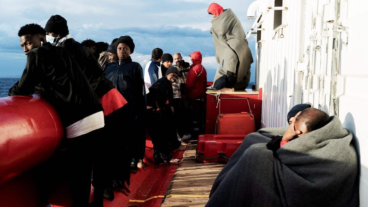 Migrantes a bordo de un barco de rescate a la espera de ser autorizados a desembarcar.