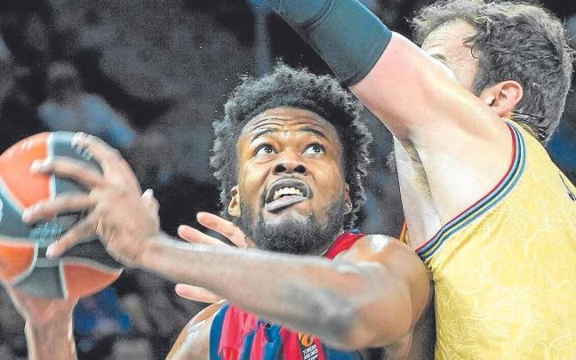 Steven Enoch se ve intimidado por Sertac Sanli en su intento de anotar en el poste bajo.