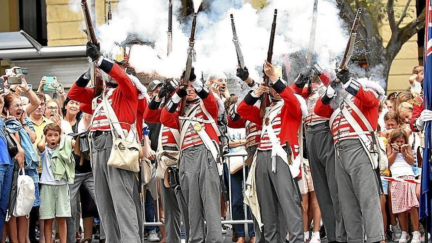 Un grupo de soldados dispara junto a la gente, impactada por el ruido.