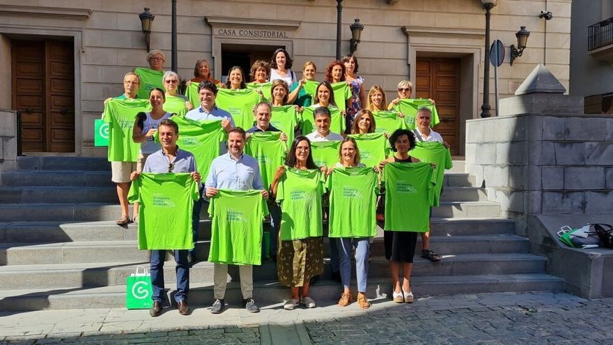 Organizadores, voluntarios y patrocinadores posan con la camiseta del evento