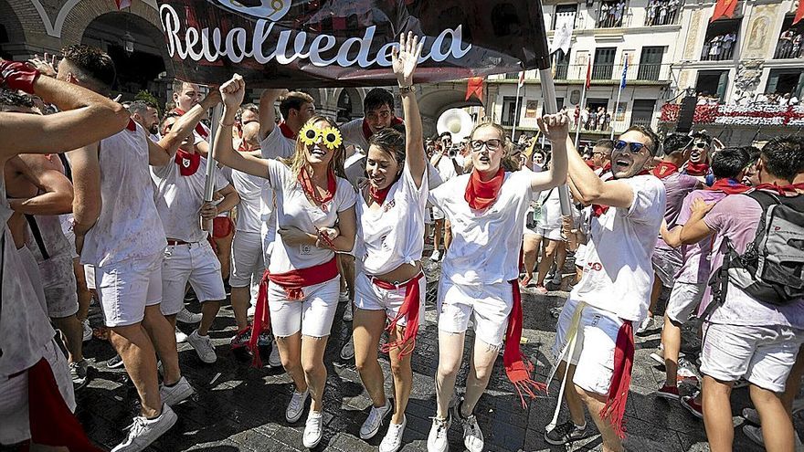 La peña La Revolvedera inicia el camino con la charanga desde la plaza de Los Fueros tras el cohete anunciador.