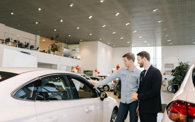 Un comprador interesado en renting toca el veh&iacute;culo que va a adquirir.