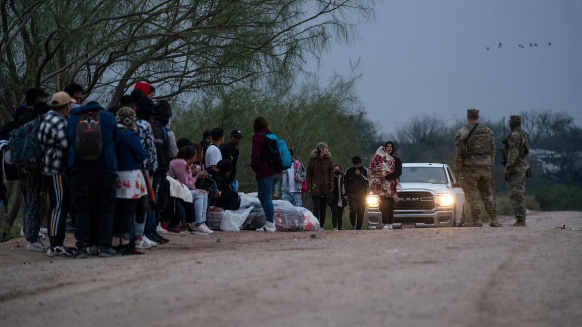 Un grupo de migrantes espera a ser recogido por la Patrulla Fronteriza en El Paso.