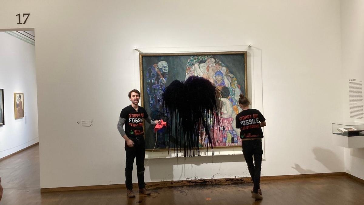 Los activistas tras arrojar el petróleo sobre el cuadro "Muerte y vida" de Gustav Klimt.