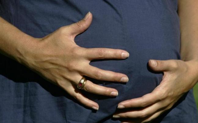 Una mujer embarazada se acaricia la barriga