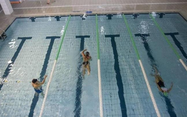 Personas nadando en una piscina.