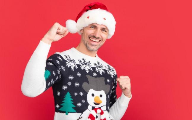 Un hombre con gorro de Pap&aacute; Noel y jersey navide&ntilde;o feo.