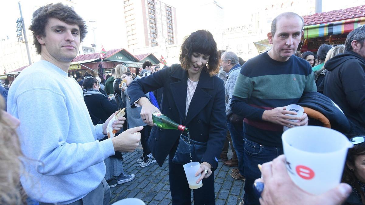 Lorena llena un vaso de txakoli en las casetas ubicadas detrás del teatro Arriaga.