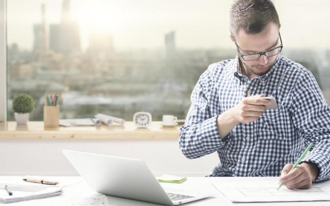 Un hombre mira su m&oacute;vil tras sentir una vibraci&oacute;n.