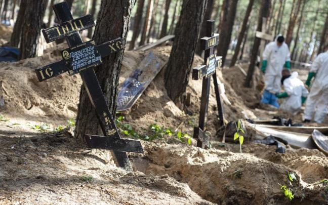 Los equipos forenses trabajan en una fosa de Izium.
