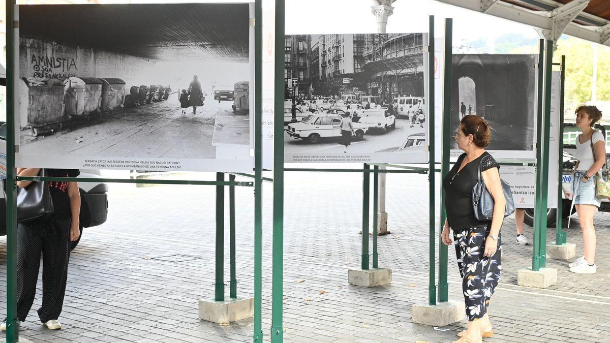 Dos mujeres contemplan la exposición itinerante ‘Caminos Escolares-Eskola Bideak’ inaugurada ayer en los tinglados próximos al Ayuntamiento de Bilbao.