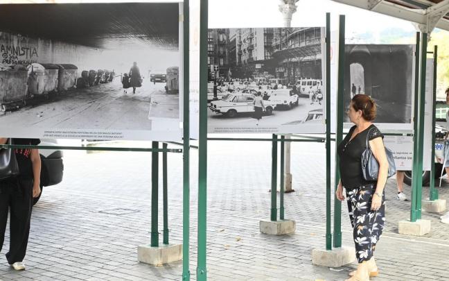 Dos mujeres contemplan la exposición itinerante ‘Caminos Escolares-Eskola Bideak’ inaugurada ayer en los tinglados próximos al Ayuntamiento de Bilbao.