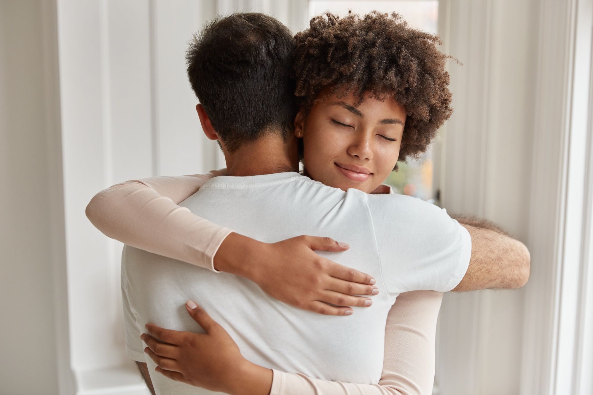 Una mujer abraza a un amigo.
