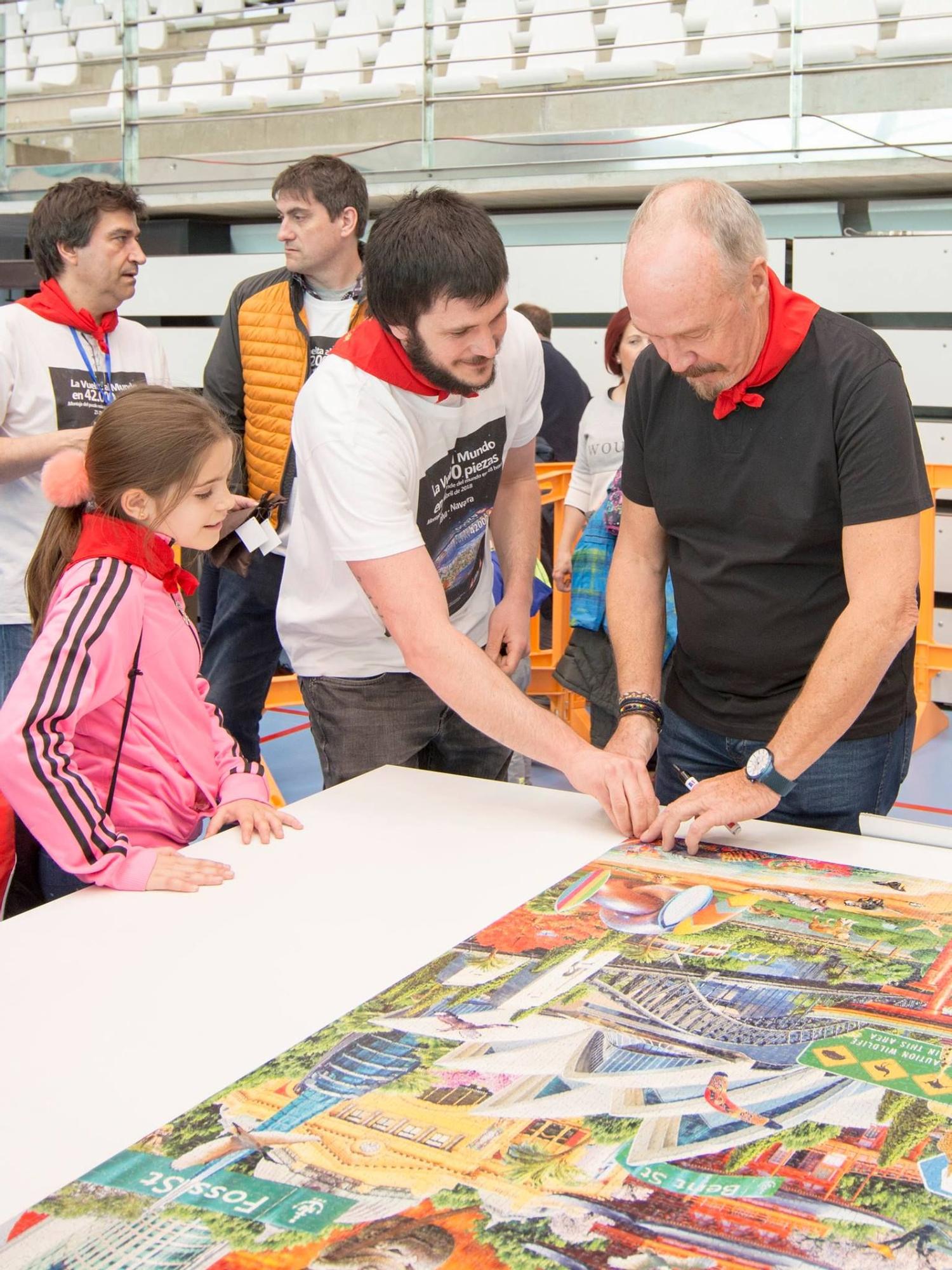 Adrian Chesterman, diseñador del puzzle 'La Vuelta al Mundo', estampa su firma con la obra ya concluida.