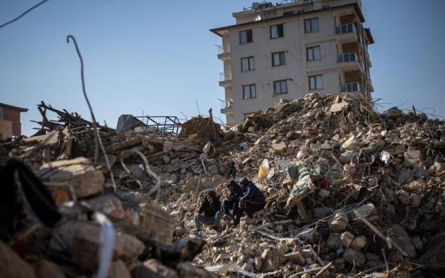 Tres hombres sentados entre las ruinas de un edificio en la ciudad turca de Hatay este martes, 14 de febrero Tres hombres sentados entre las ruinas de un edificio en la ciudad turca de Hatay este martes, 14 de febrero
