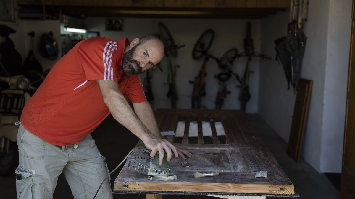 Javier Villegas lija una puerta en el garaje de su casa. Lleva 18 años viviendo en el pueblo viejo de Berriozar.