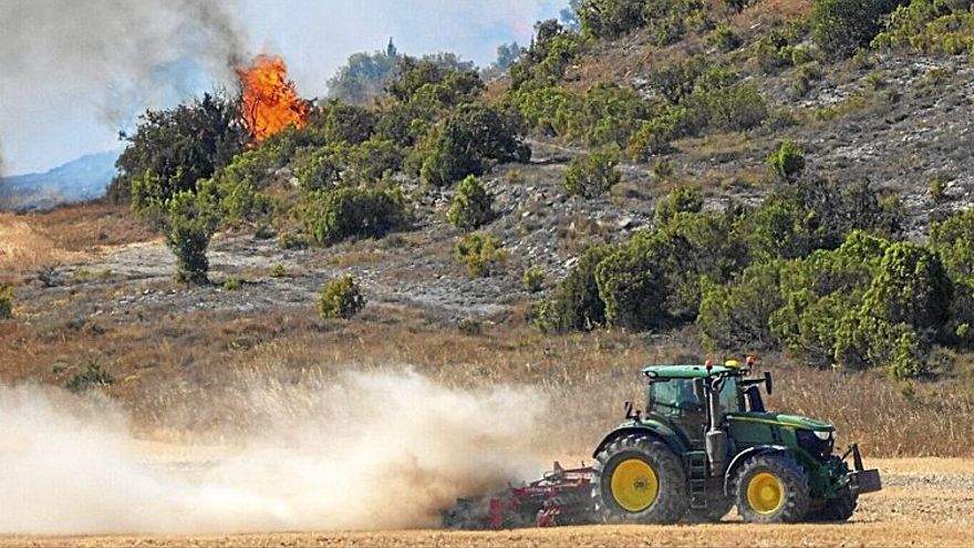 Un agricultor ayuda con su tractor a hacer un cortafuegos para controlar el incendio del lunes en Mendoza.