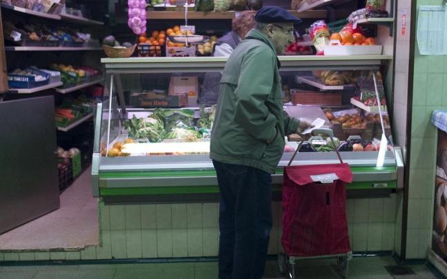 Lerro hauekin batera dagoen irudian, gizon batek erosketa bat egiten du Gasteizko saltoki batean.