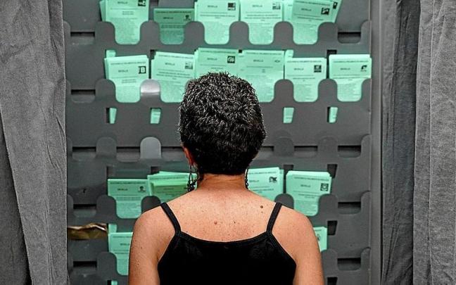 Una electora observa las diferentes papeletas en un colegio electoral de Sevilla el pasado día 19. | FOTO: E. P. Una electora observa las diferentes papeletas en un colegio electoral de Sevilla el pasado día 19. | FOTO: E. P.