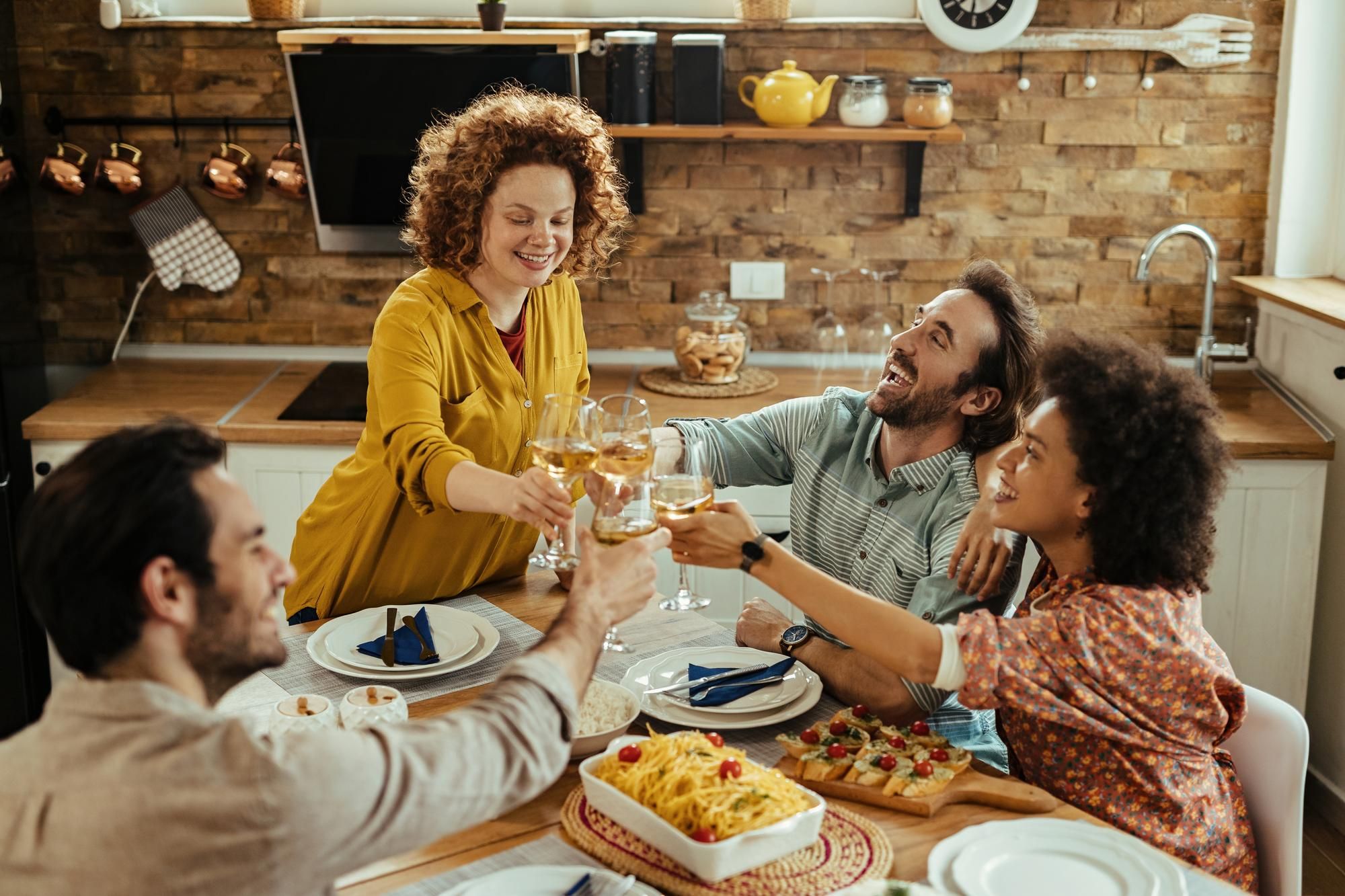 Una pareja cena con amigos en su casa.