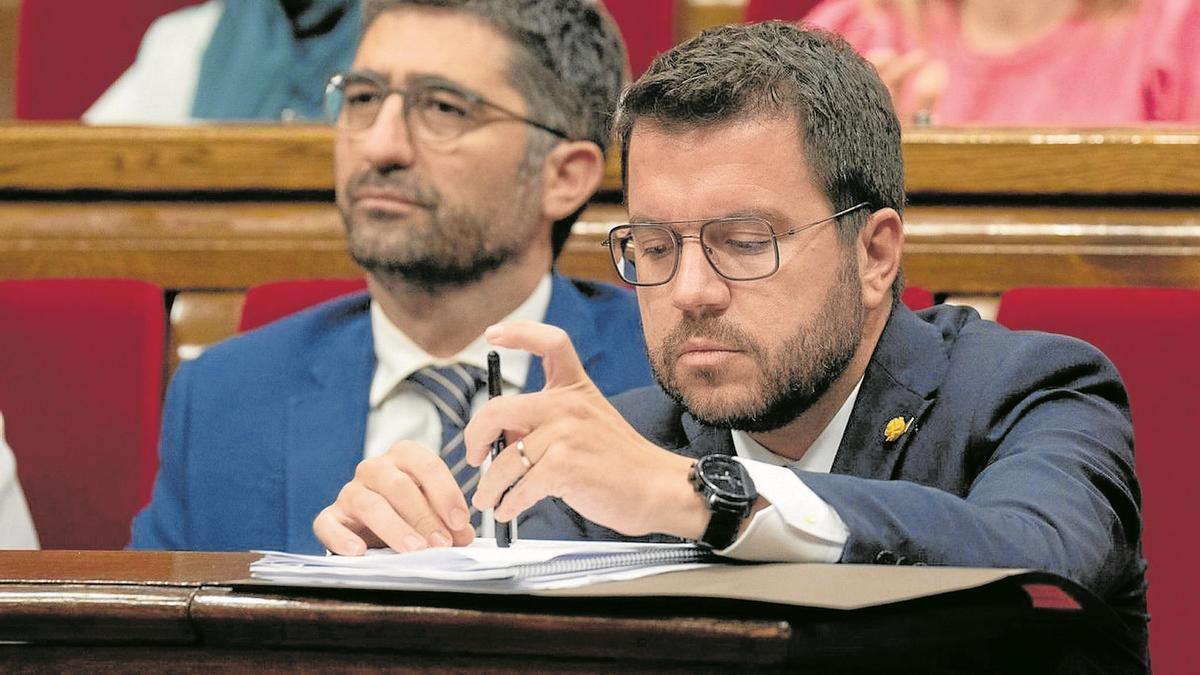 Pere Aragonès, con gesto cabizbajo junto a Jordi Puigneró, en la jornada del debate de política general celebrada el pasado martes en el Parlament.