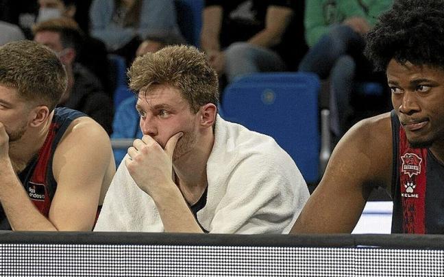 Giedraitis, Kurucs y Enoch siguen atentamente el desarrollo de un partido desde el banquillo.