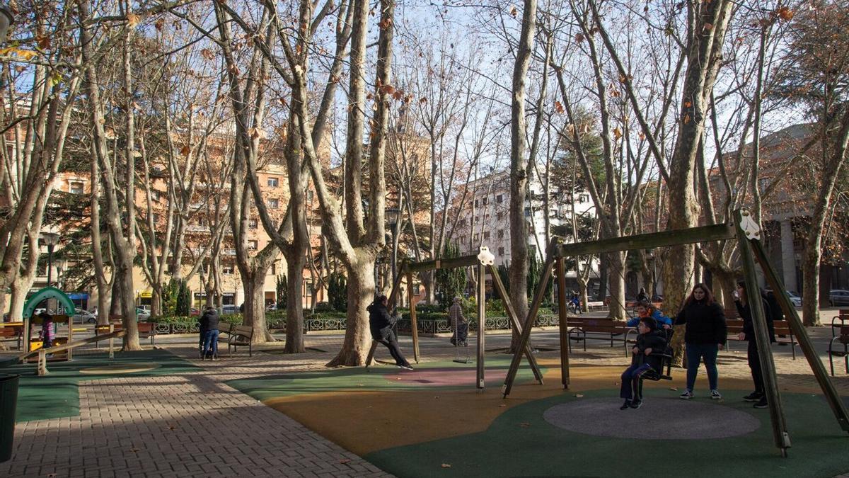 Vista de la Plaza de la Cruz con niños en los columpios