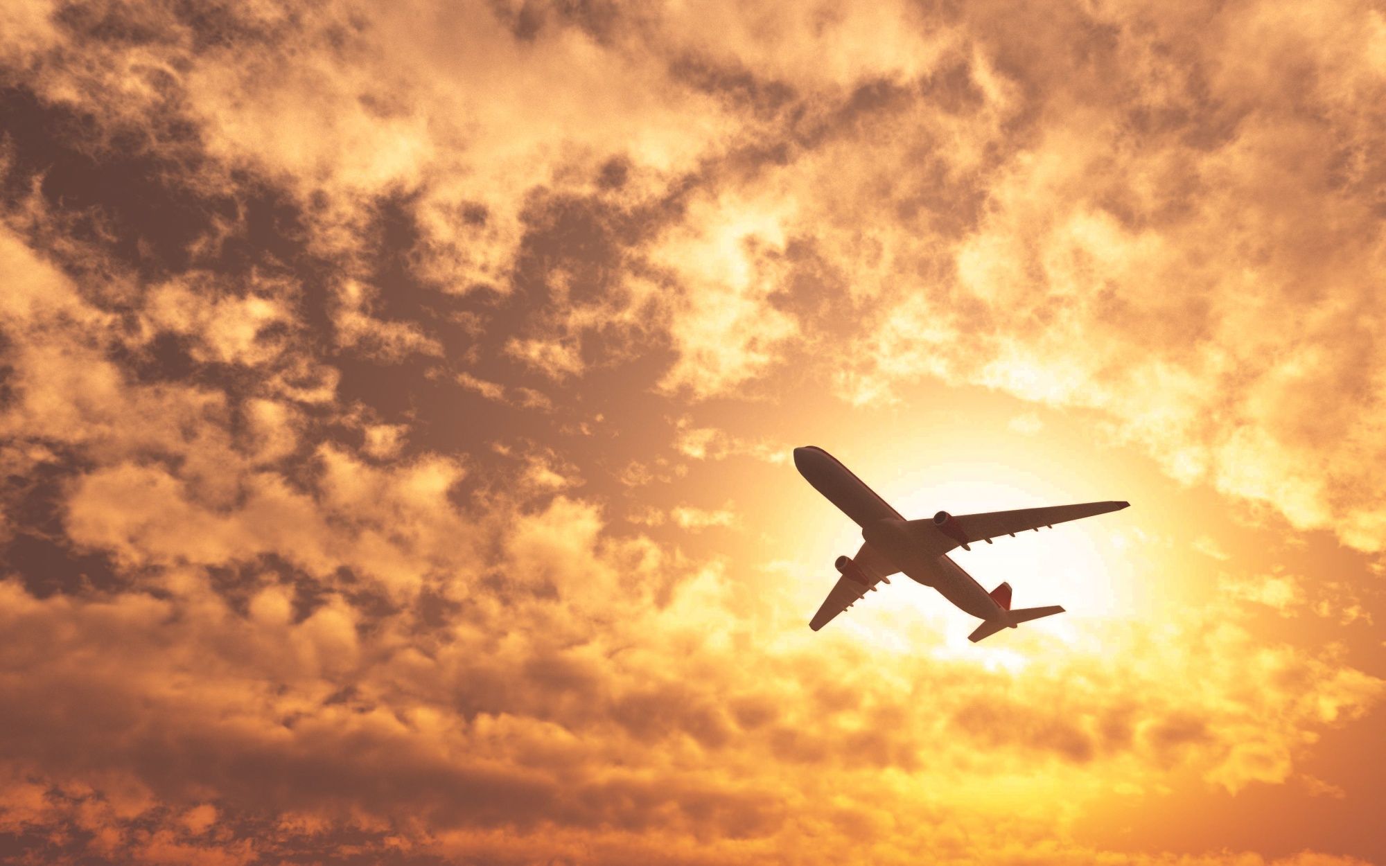 Un avión pasa por el sol en un día nublado.