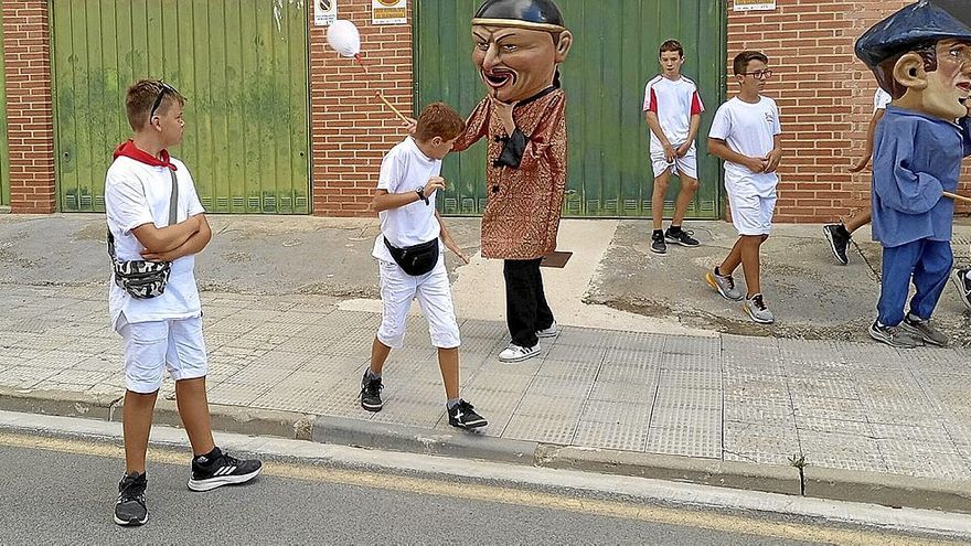 El chino, el nuevo cabezudo, por las calles de Sangüesa junto a varios niños y niñas.