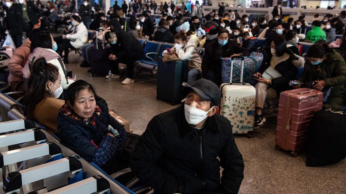 Numerosos pasajeros esperan en la estación de tren de Wuhan.