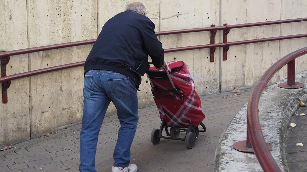 Un vecino de avanzada edad sube con dificultad por la zona peatonal de la rotonda.