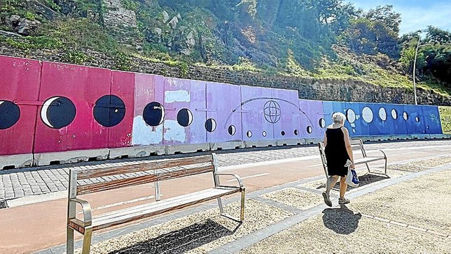 Una mujer camina junto a la zona protegida por un muro de hormigón de 95 metros.