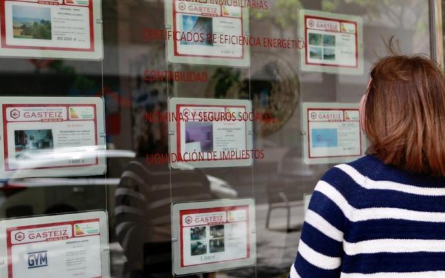 Una joven observa el escaparate e una inmobiliaria. Una joven observa el escaparate e una inmobiliaria.