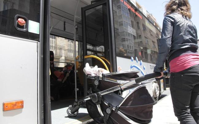 Una mujer ajena a esta información accede a un autobús con un carrito de bebé