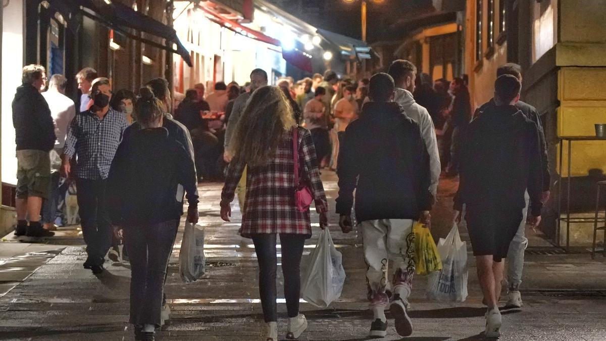 Jóvenes con bolsas con bebidas alcohólicas.