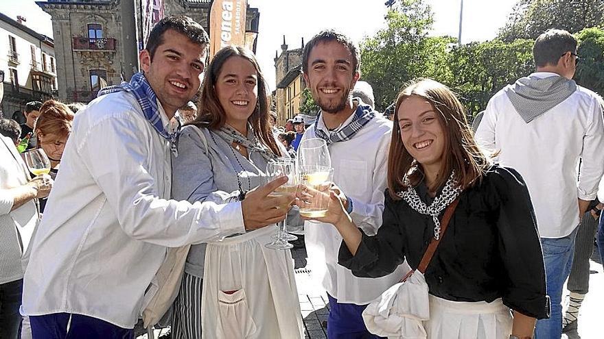 Una cuadrilla de jóvenes brinda con sidra en el multitudinario txotx que animó la Plaza.