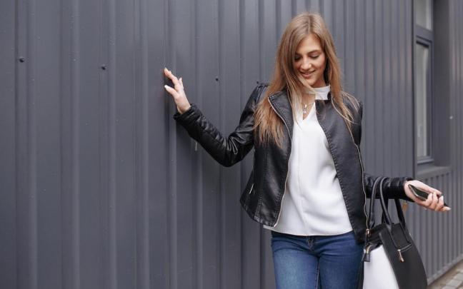 Una mujer posa con una cazadora negra efecto piel.