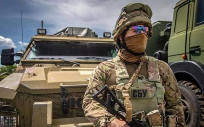 Un soldado ucraniano frente a un vehículo blindado.