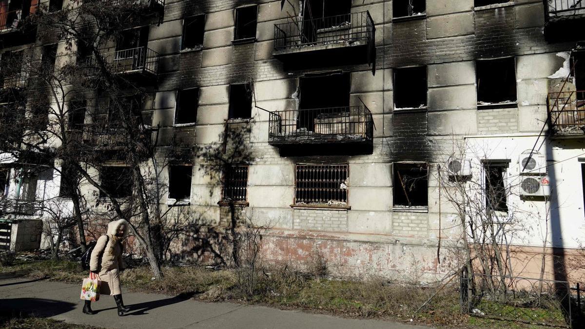 Una mujer pasea ante un edificio bombardeado en Lugansk.