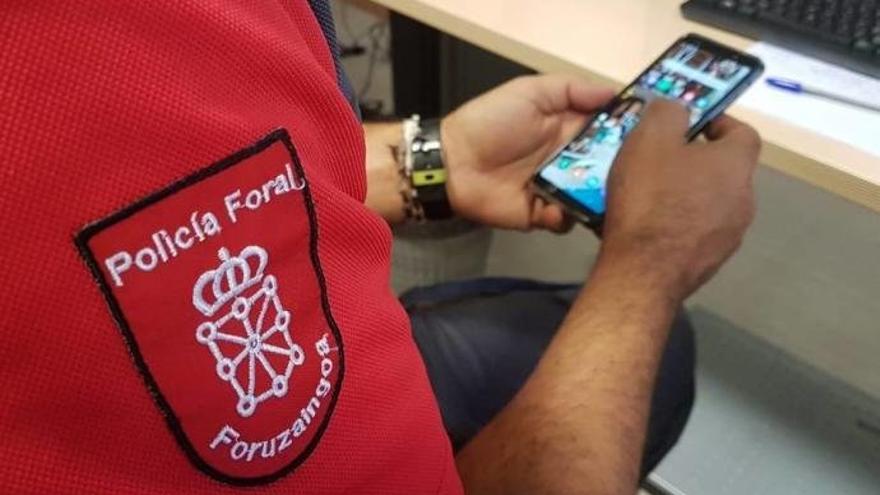 Un agente de la Policía Foral con un teléfono móvil.