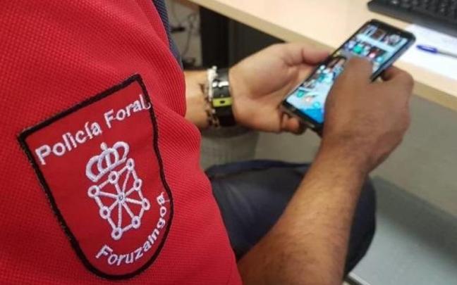Un agente de la Policía Foral con un teléfono móvil.