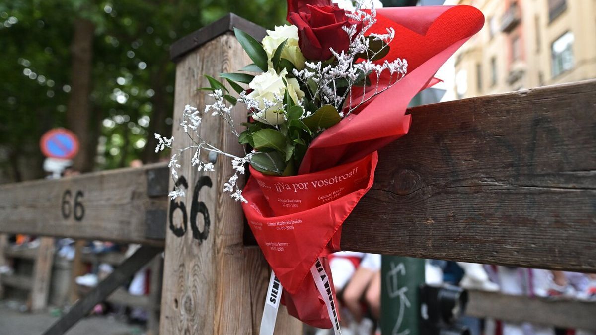 Los padres de Daniel Gimeno colocan un ramo de flores come homenaje a su hijo, este domingo en Pamplona.