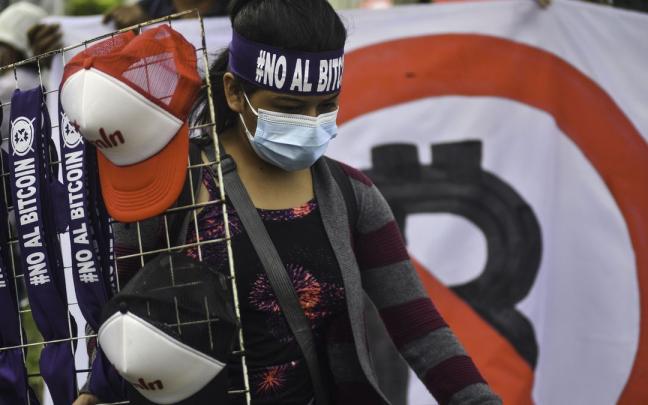 Una salvadoreña protesta contra la implantación del bitcoin en el país. Una salvadoreña protesta contra la implantación del bitcoin en el país.