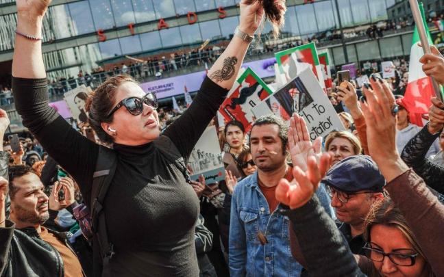 Una mujer se corta el pelo en Suecia en señal de apoyo a las mujeres iraníes. Una mujer se corta el pelo en Suecia en señal de apoyo a las mujeres iraníes.