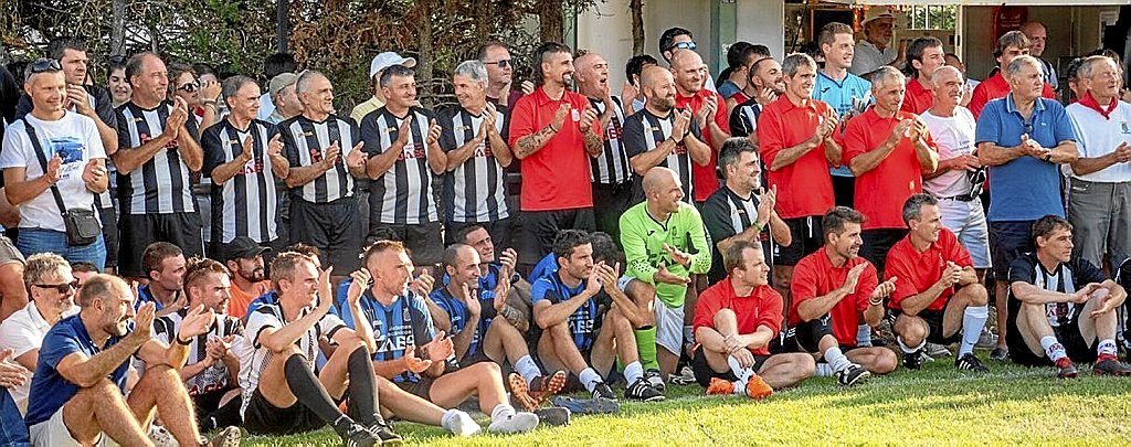 Ambiente de celebración en el campo con jugadores de diversas épocas.