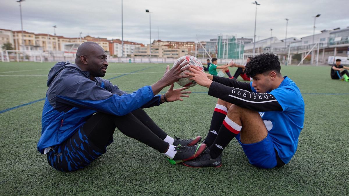 Iba Sow y Charaf Ayoujil hacen abdominales.